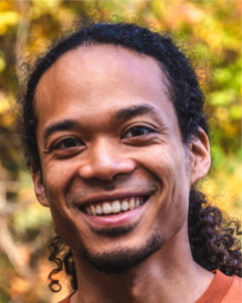 A man smiles for a brightly-colored portrait.